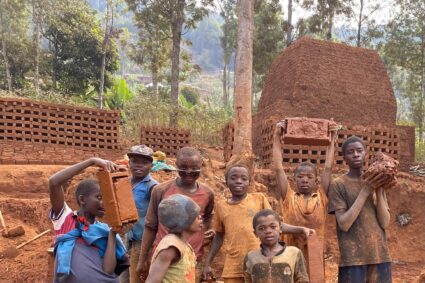 Kaziba : pendant les vacances, des enfants transforment la terre rouge en briques pour préparer leur avenir